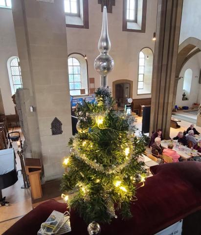 ein kleiner Weihnachtsbaum mit LED-Lichtern steht auf der Kanzelbrüstung über der Vesperkirche