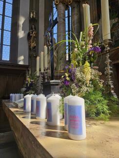 Viele Kerzen mit dem "Einfach heiraten" Logo stehen auf dem blumengeschmückten Altar